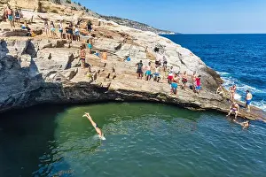 Thassos, Greece - July 20, 2019: Tourists are doing diving in the natural swimming pool Giola in Thassos island, Greece