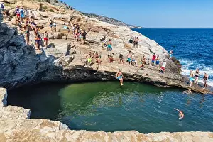 Thassos, Greece - July 20, 2019: Tourists are doing diving in the natural swimming pool Giola in Thassos island, Greece