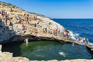 Thassos, Greece - July 20, 2019: Tourists are doing diving in the natural swimming pool Giola in Thassos island, Greece