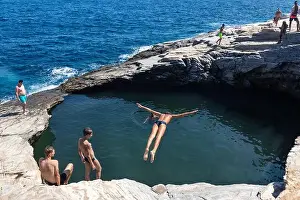Thassos Prints: Thassos, Greece - July 20, 2019: Tourists are doing diving in the natural swimming pool Giola in Thassos island