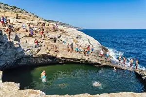 Thassos Prints: Thassos, Greece - July 20, 2019: Tourists are doing diving in the natural swimming pool Giola in Thassos island