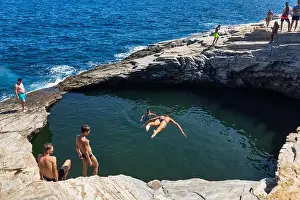 Thassos, Greece - July 20, 2019: Tourists are doing diving in the natural swimming pool Giola in Thassos island, Greece