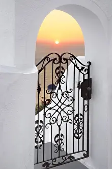 White Walls Prints: Thira (capital city of Santorini) - doorway with white walls and the sunset in the background