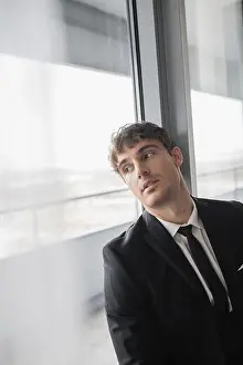 Well Dressed Prints: thoughtful man in classic formal wear with black tie and white shirt standing in modern hotel room