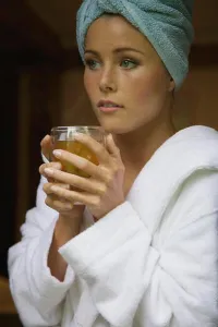 Dreaming Prints: Thoughtful woman in bathrobe holding herbal tea at home
