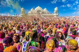 Frolic Prints: Thousands of people throw colored powder into the air during the Holi Festival of Colors at the Sri Sri Radha Krishna