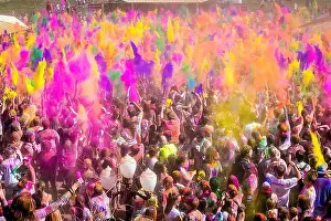 Frolic Prints: Thousands of people throw colored powder into the air during the Holi Festival of Colors at the Sri Sri Radha Krishna