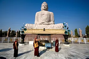Tibetan Prints: Tibetan monks snapping souvenir pictures under a giant Statue of Buddha Shakyamuni