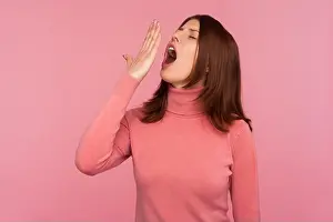 Wake Prints: Tired woman with brown hair in pink sweater yawning closing mouth with hand