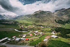Tkarsheti Village On Mountain Background In Kazbegi District, Mtskheta-Mtianeti Region, Georgia. Landscape At Spring Or Summer Season
