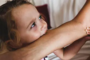 Body Part Prints: Toddler female biting the arm of the mother