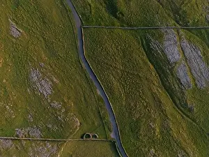 Winding Road Prints: A top-down shot capturing a serpentine road meandering through a rugged