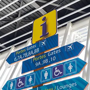 Directional Prints: Totem with different information signs for passengers at the airport showing gates