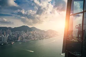 Tourists enjoying Hong Kong city views from the Sky 100 Observation Deck in West Kowloon at Hong Kong. Asian tourism, modern city life, or business fi