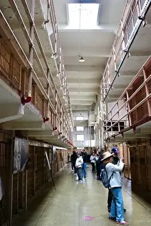 The Rock Prints: Tourists inside Alcatraz Federal penitentiary looking up at corridors with prison cells Alcatraz Island San Francisco