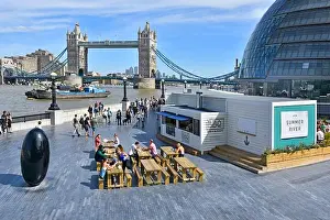 Tower Bridge Prints: Tourists & office workers lunch time at fast street food stall riverside alfresco snacking at picnic tables River