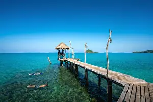 Tourists snorkel in crystal turquoise water near tropical resort at Koh Mak island in Trat, Thailand. Summer, Vacation, Travel and Holiday concept