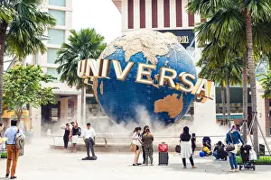 Carousel Prints: Tourists and theme park visitors taking pictures of the large rotating globe fountain in front Universal Studios