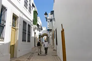 Unrecognizable Prints: Tourists walking on street with traditional houses, Sidi Bou Said, Tunis, Tunisia