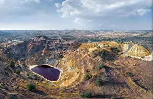 Toxic lake in abandoned open pit copper mine and waste heaps near Kampia, Cyprus. Aerial panorama