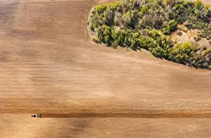 Tractor Plowing Field In Spring. Beginning Of Agricultural Season. Cultivator Pulled By A Tractor In Countryside Rural Field. Countryside Field