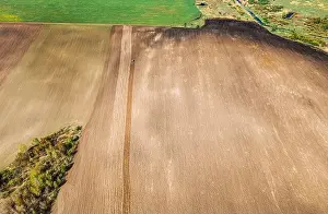 Tractor Plowing Field In Spring. Beginning Of Agricultural Season. Cultivator Pulled By A Tractor In Countryside Rural Field. Countryside Field