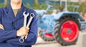 Maintain Prints: Tractor Pro Mechanic. Caucasian Service Worker with Heavy Duty Wrench Preparing For Complicated Tractor Fix