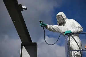 Beams Prints: Tradesman spray paints the steel beams on a construction site