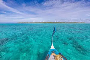 Traditional Maldivian boat Dhoni with amazing tropical island background view. Nature paradise beach, open sea view, seascape in Maldives, luxury