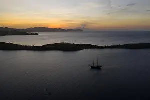 Pirate Ship Prints: A traditional Pinisi schooner sails at sunset in Komodo National Park
