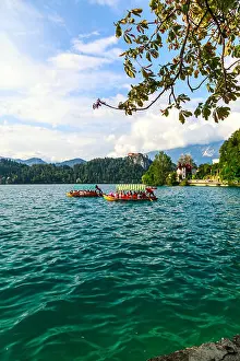 Blue Boat Prints: Traditional Pletna boats and tourists in the Lake Bled located in Slovenia -Bled