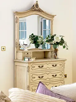 Flower Arrangement Prints: A detail of a traditional, sitting room a decorative white wood chest of drawers with mirror