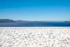Images Dated 25th July 2021: Traditional white architecture on Santorini island, Greece. White pebbles over blue sea view