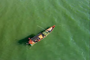 Slow Travel Prints: Traditional wooden fishing boat floats on calm green waters off the coast of Kep