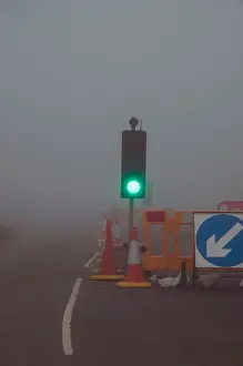 Speeding Prints: Traffic light on green foggy road uk