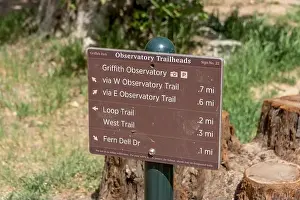 Trailhead sign for Griffith Observatory west and east trails with Fern Dell Drive