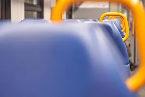 Functionality Prints: Empty train interior with blue seats and yellow handrails in focused perspective