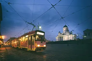 White Church Prints: Tram passing Helsinki Senate Square during sunset with Helsinki Cathedral in the background at Finland