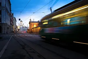 Tram passing Helsinki Senate Square during sunset with Helsinki Cathedral in the background at Finland