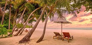 Sunset Beach Prints: Tranquil tropical sunset scenery couple sun bed loungers