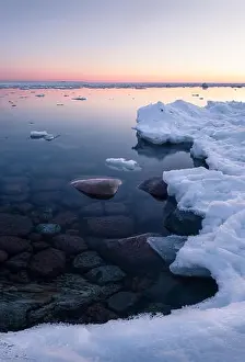Standing Stone Prints: Tranquil winter sunset with melt sea and clean snow at beautiful peaceful evening in Finland