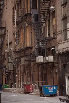 Garbage Can Prints: trash dumpster garbage dustbins and fire escape stairwells staircases in a back alley in inner city america usa