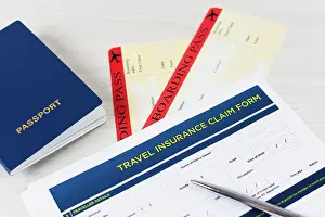 Passport Prints: Travel insurance claim form with a boarding pass and passport on white wooden table