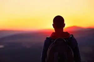 Moody Sky Prints: Traveler with backpack watching amazing sunset
