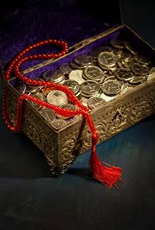 Middle Eastern Prints: A treasure box filled with UAE Dirham coins with Islamic rosary placed over