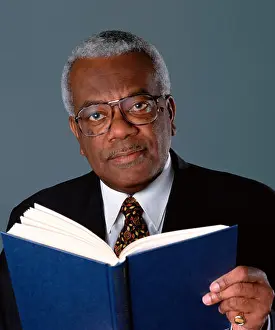 Literacy Prints: Trevor McDonald holding a book