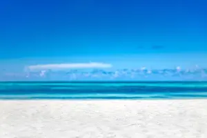 Empty tropical beach background. Horizon with sky and white sand. Paradise island shore or coast