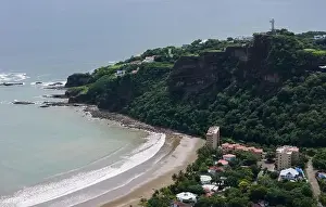 Tropical beach in San Juan Del Sur aerial view on cliff with jesus statue background