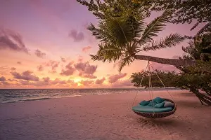 Tropical beach sunset landscape with beach swing or hammock and sunset sky white sand and calm sea for beach banner. Perfect beach scene vacation