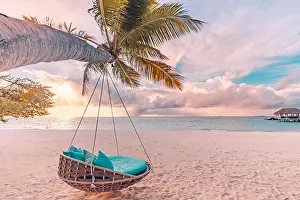 Tropical beach sunset panorama as summer landscape with beach swing hammock and white sand, calm sea for beach banner. Perfect beach scene vacation